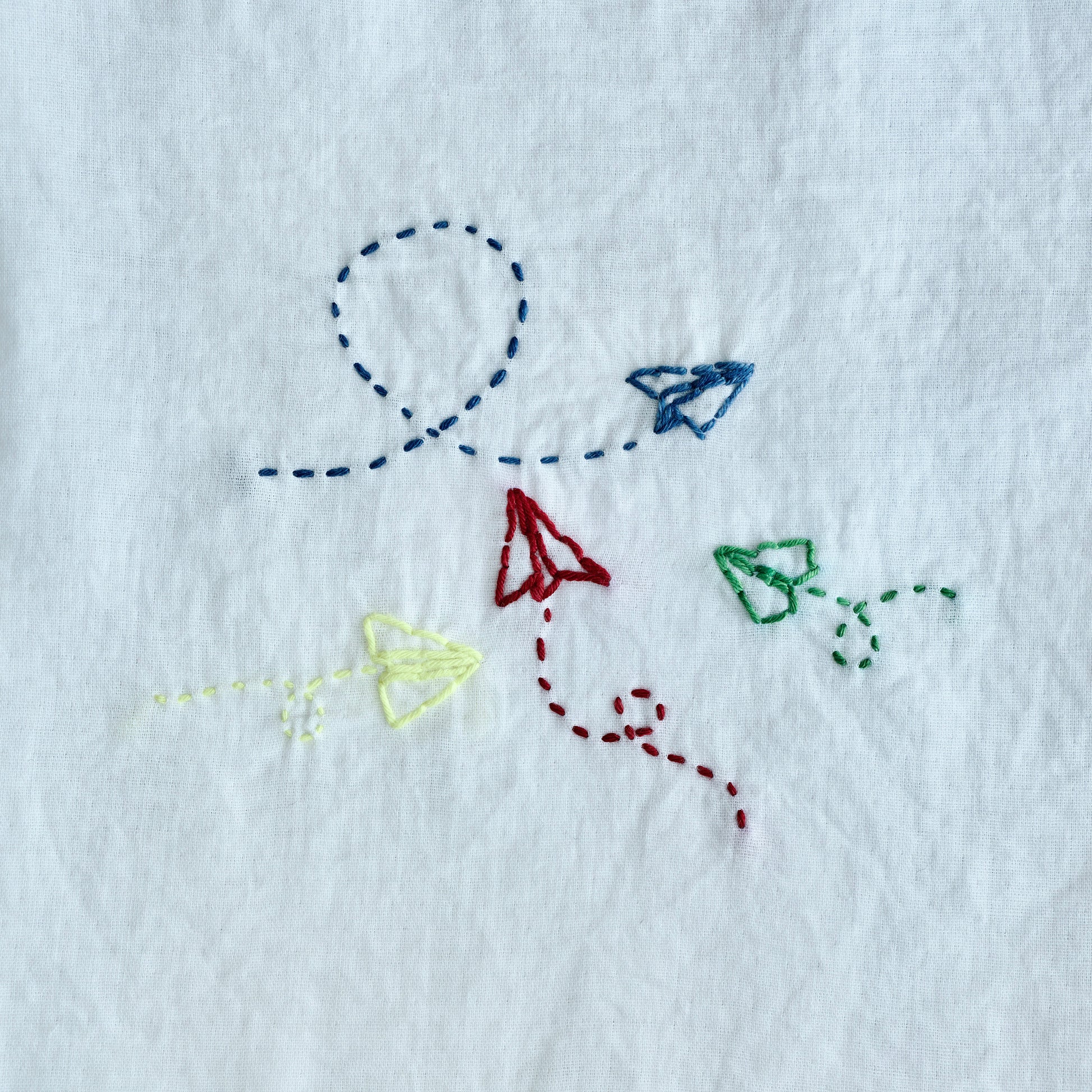 Finished Sashiko embroidery of an airplane for the letter A on white fabric.