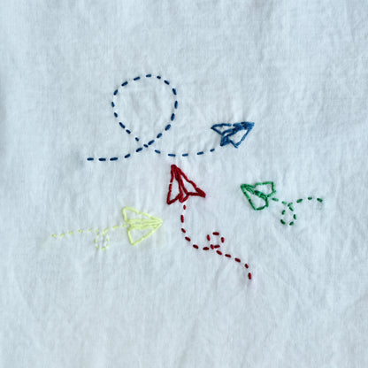 Finished Sashiko embroidery of an airplane for the letter A on white fabric.