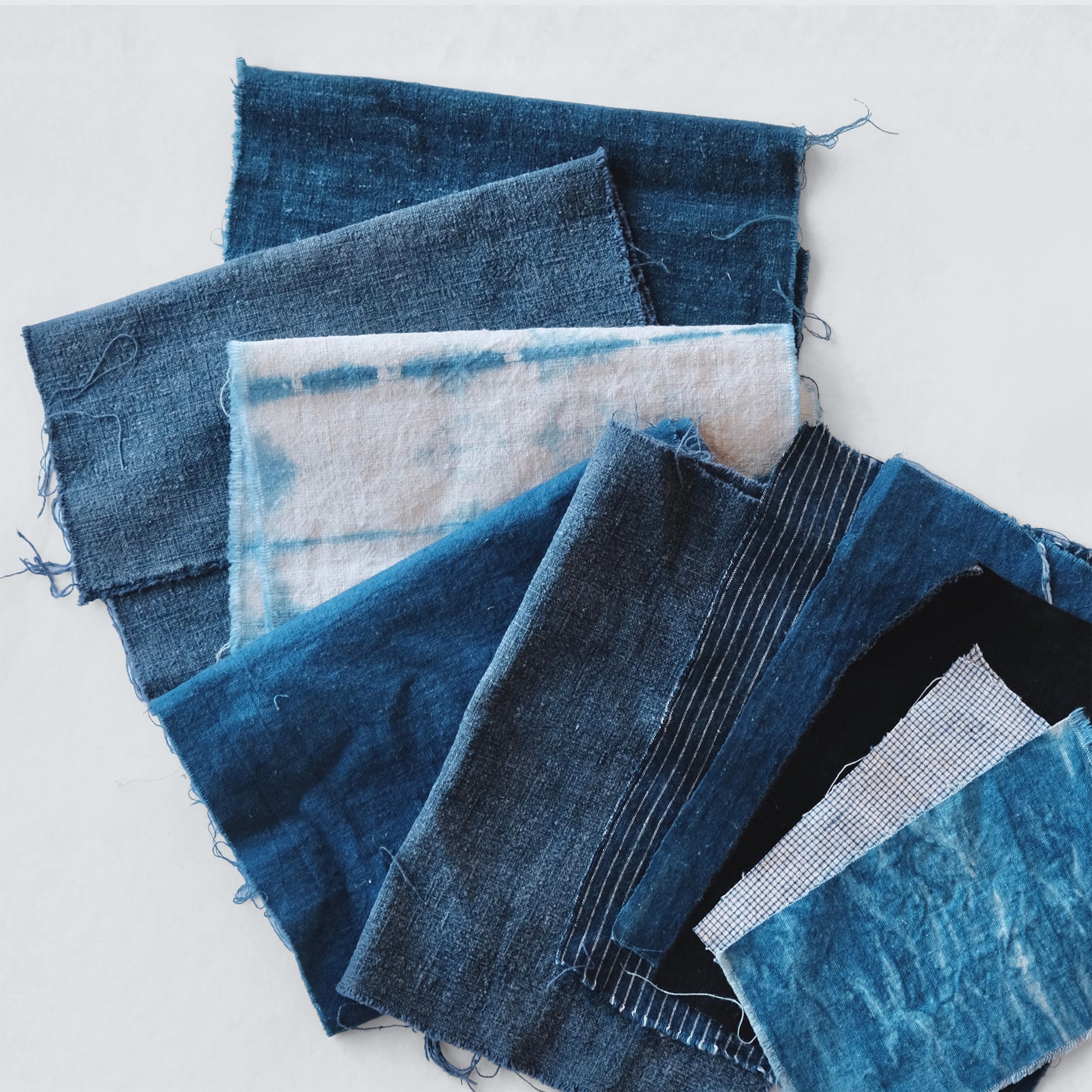 Curated Boro fabric bundle featuring 10 pieces of antique indigo hand woven cotton and French linen textiles.