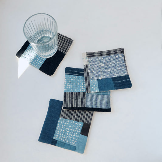 Set of four handcrafted Boro patchwork coasters with glass on indigo fabric.