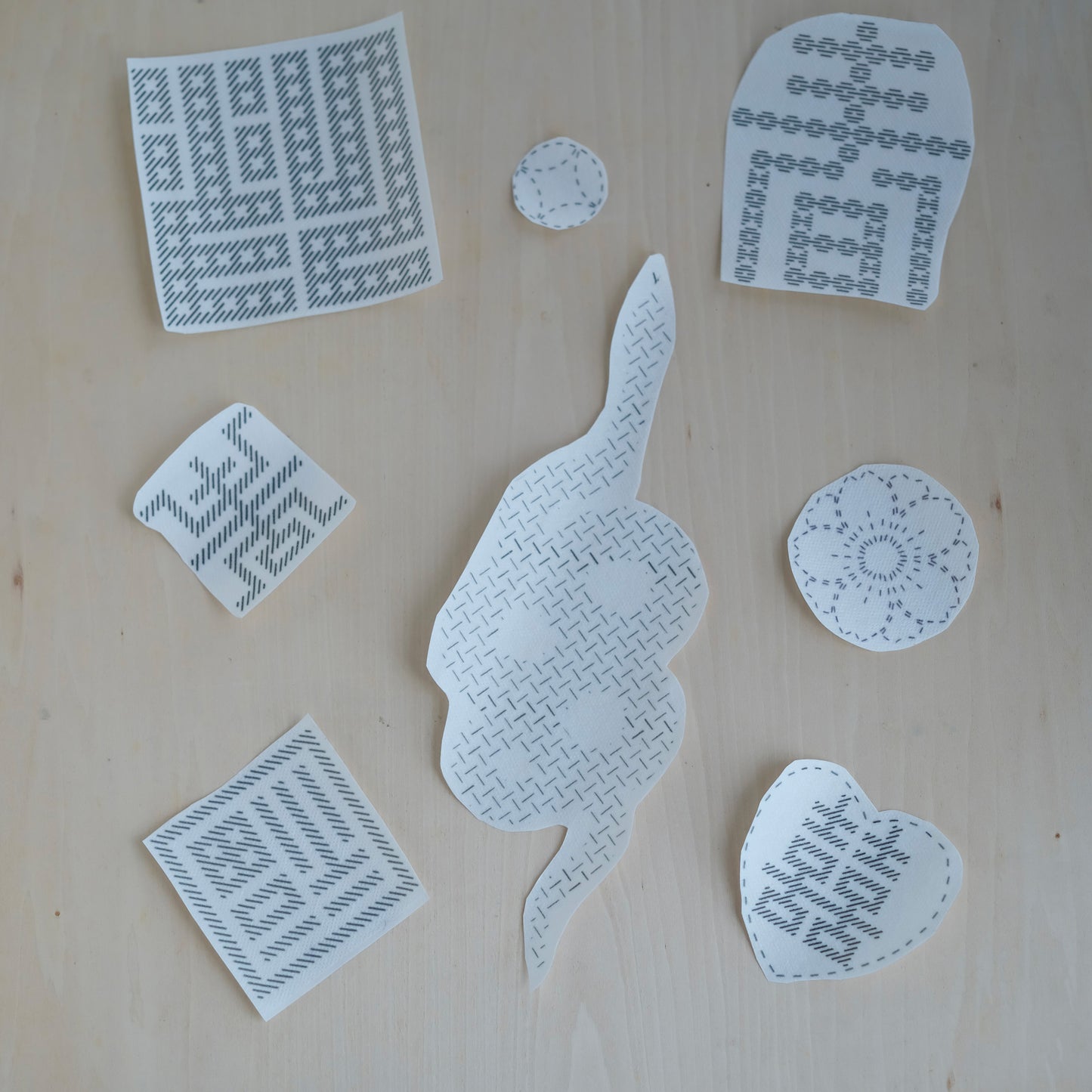 Eight individual stick and stitch embroidery transfers featuring Chinese symbols and tattoo-inspired art.