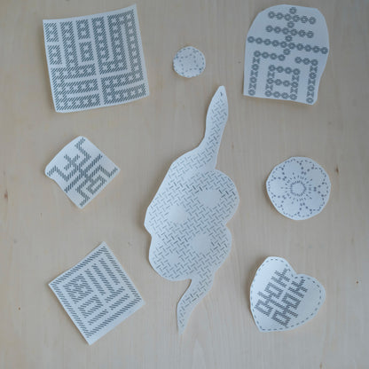 Eight individual stick and stitch embroidery transfers featuring Chinese symbols and tattoo-inspired art.