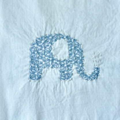 Hand-stitched elephant Sashiko pattern on fabric for the letter E.