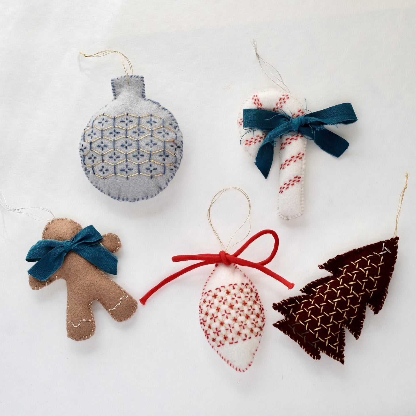 Five finished Christmas ornaments featuring traditional Japanese Sashiko patterns on wool felt.