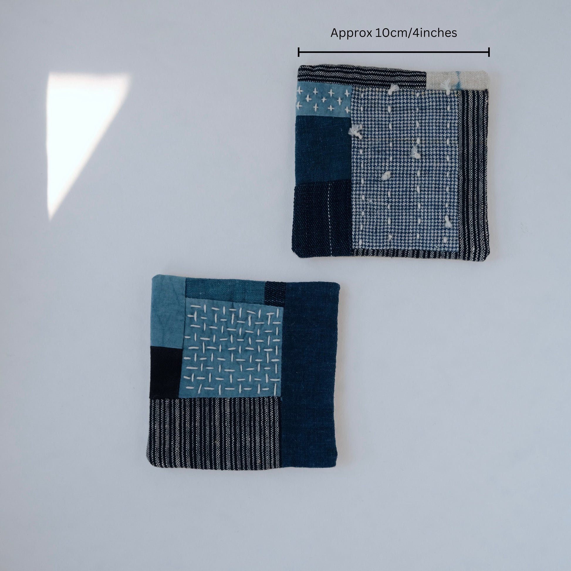 set of 2 Hand-quilted Sashiko drink coasters measuring approximately 4 inches.