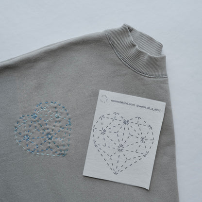 Detailed view of multiple diamond heart Sashiko patterns stitched onto a comfortable sweatshirt.
