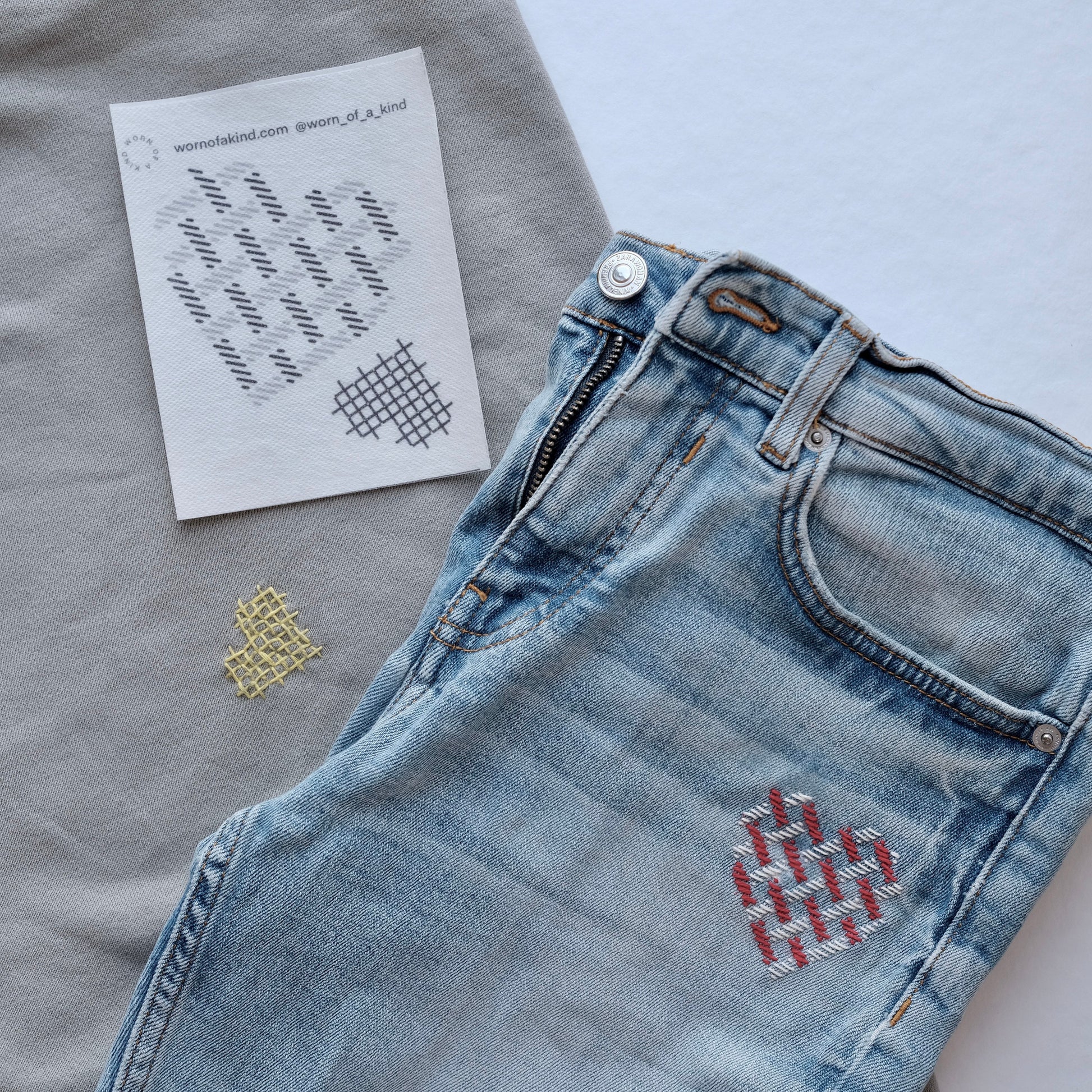 Heart-themed Sashiko mending on a denim patch and a sweatshirt using the Love Mends kit.