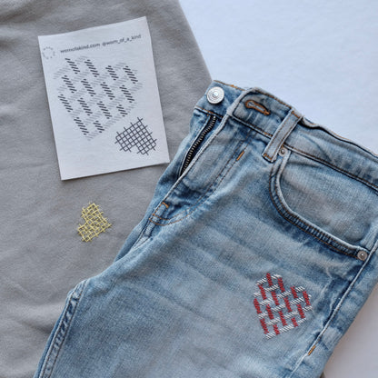 Heart-themed Sashiko mending on a denim patch and a sweatshirt using the Love Mends kit.
