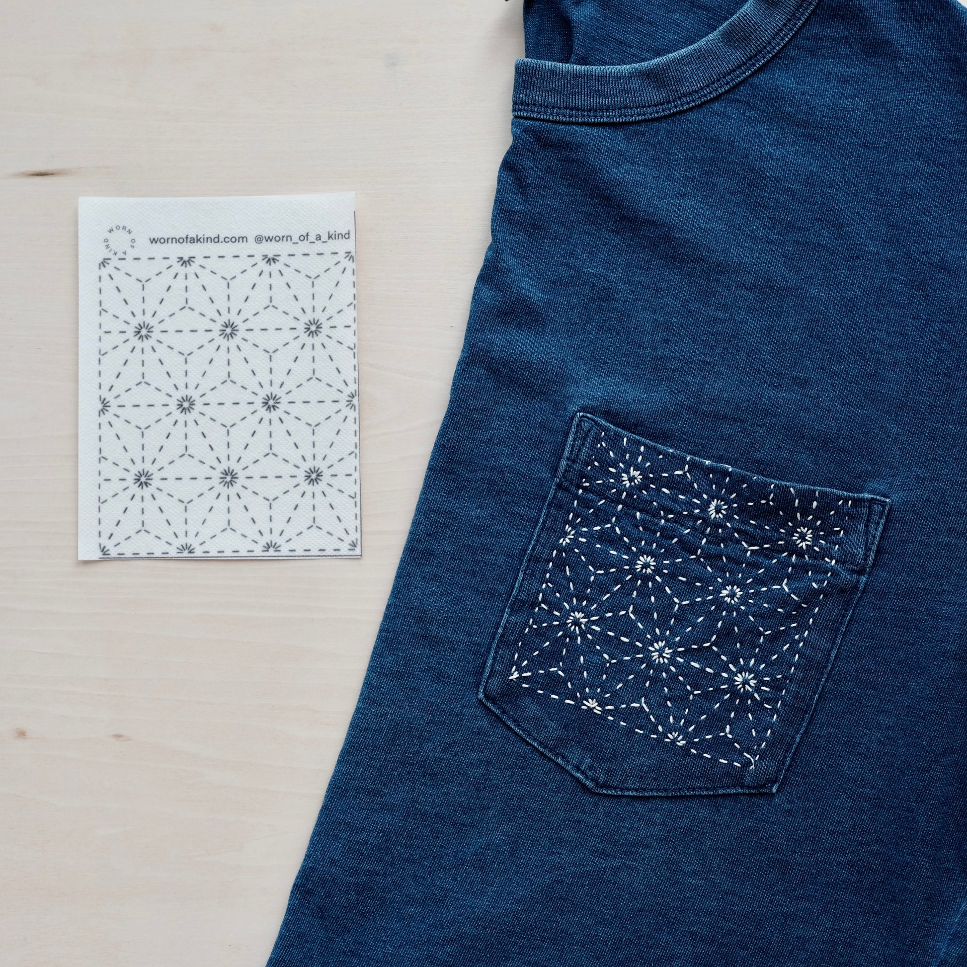 Printed hemp leaf Sashiko transfer next to a finished indigo t-shirt pocket repair.
