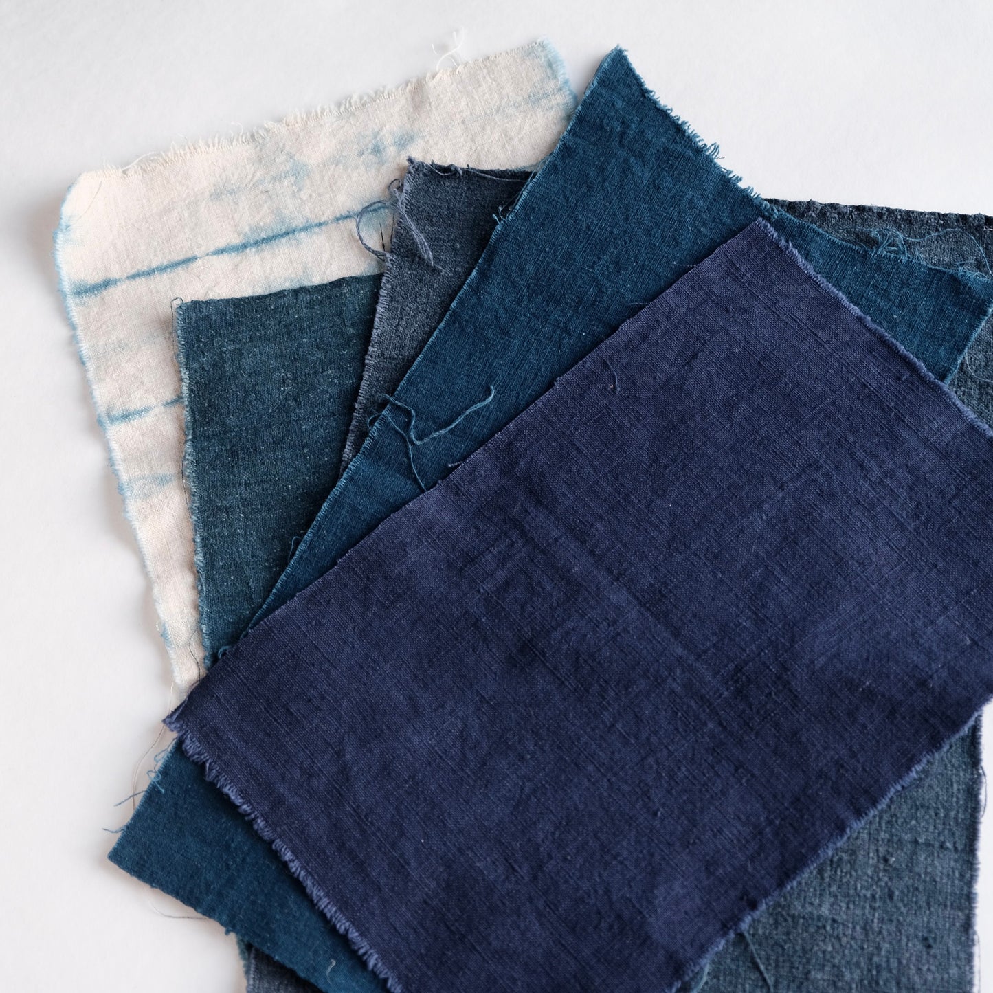 Close-up of large antique indigo and French linen pieces from the bundle.
