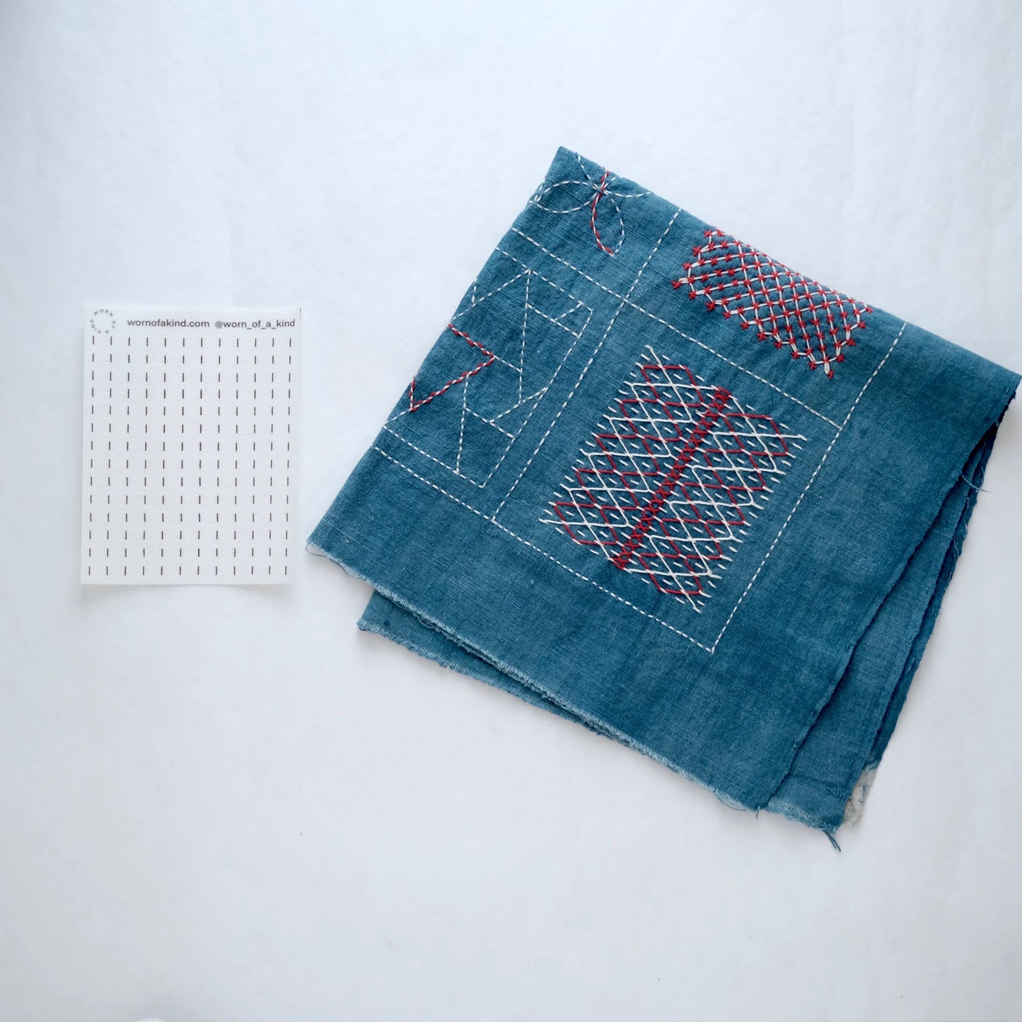 Finished indigo Sashiko sample showing the two-step Kugurizashi stitching and weaving process.