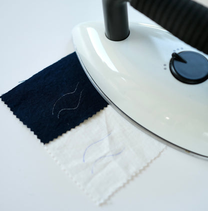 Demonstration of fabric markings disappearing under a hot iron.