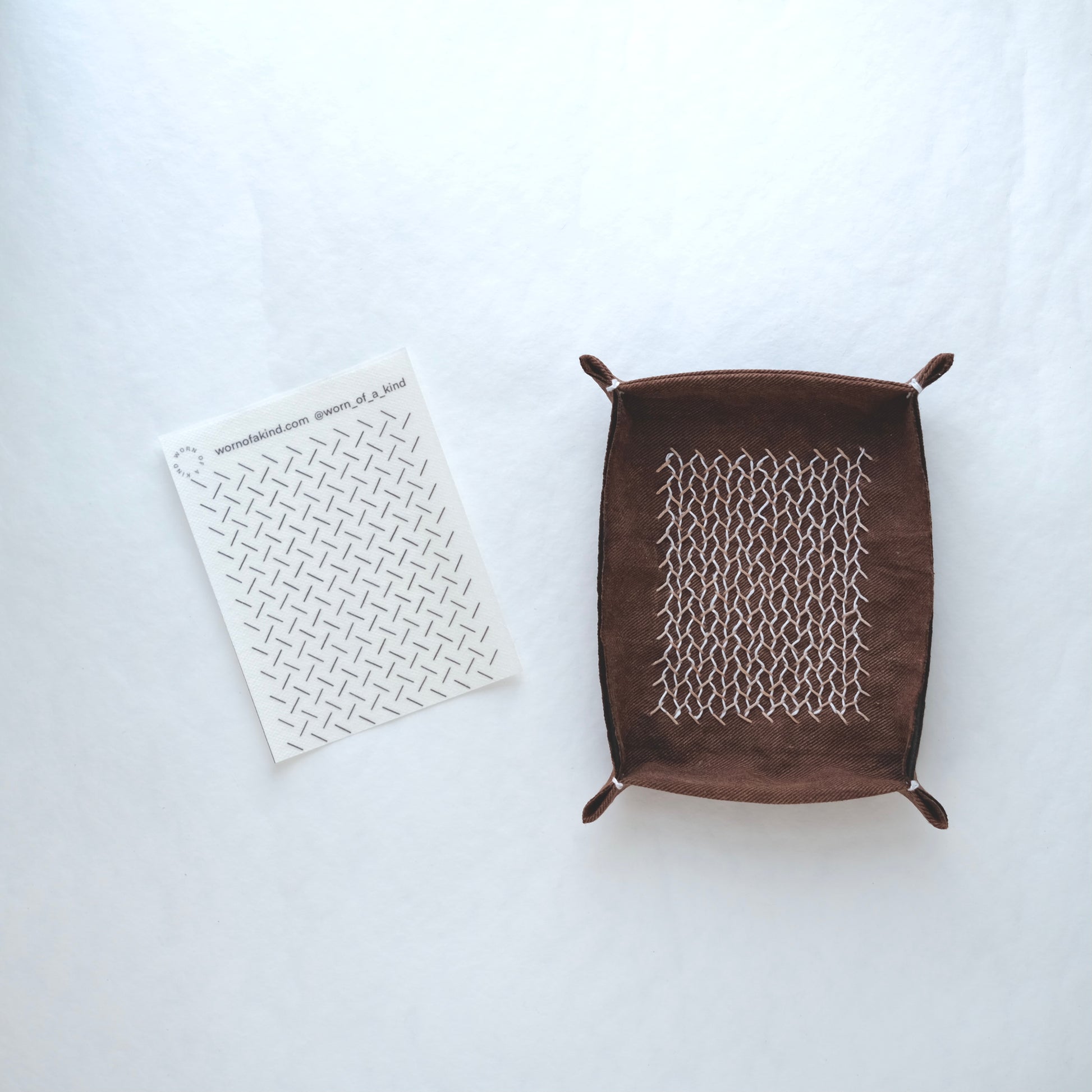 A handmade fabric tray featuring a finished Kugurizashi woven design and the corresponding transfer.