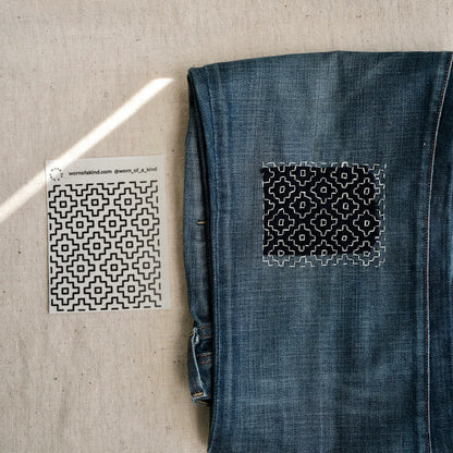 Close up of a Persimmon Flower (Kakinohana) Sashiko transfer sheet and finished denim repair.