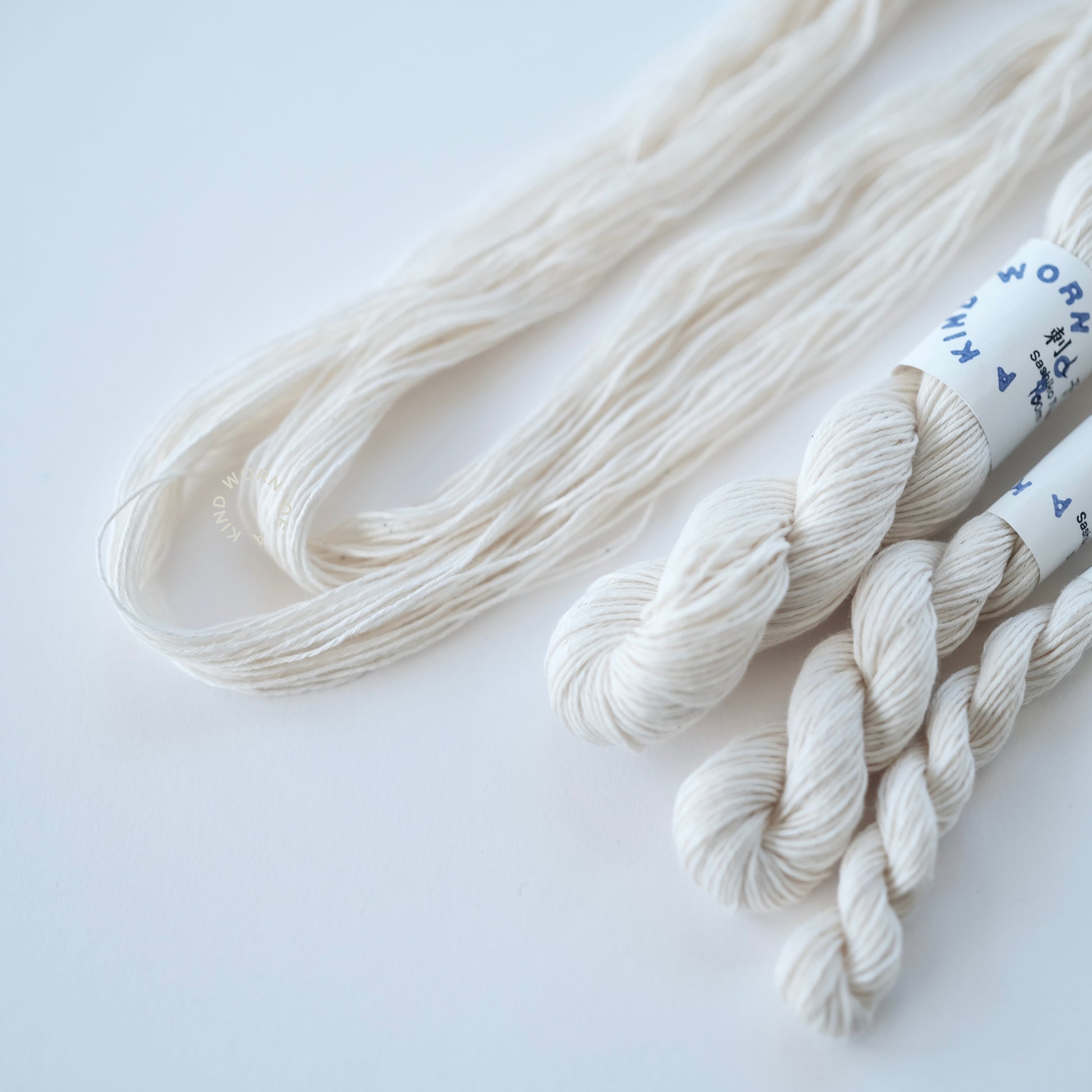 Close-up of twisted and opened skeins of natural unbleached Sashiko cotton.