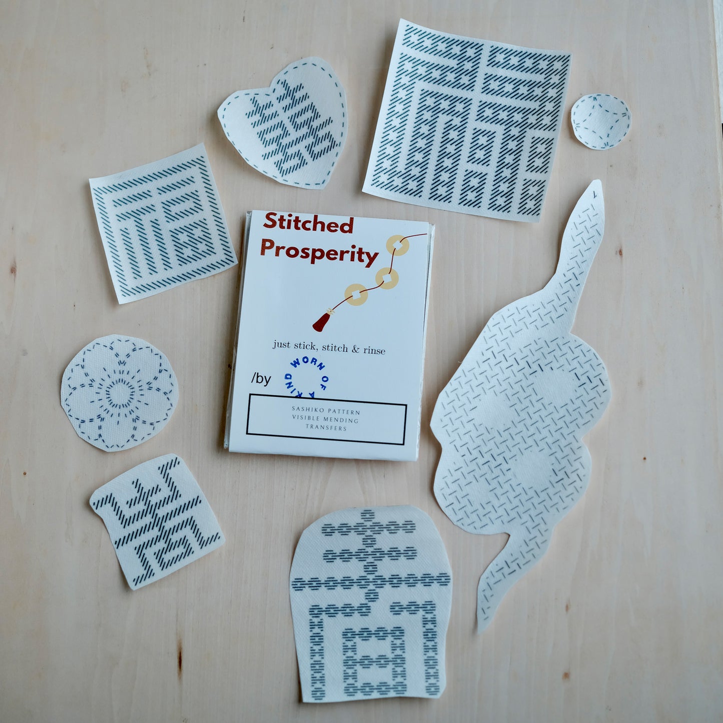 Flat lay of 8 water-soluble sashiko transfers surrounding the recycled cardboard packaging.