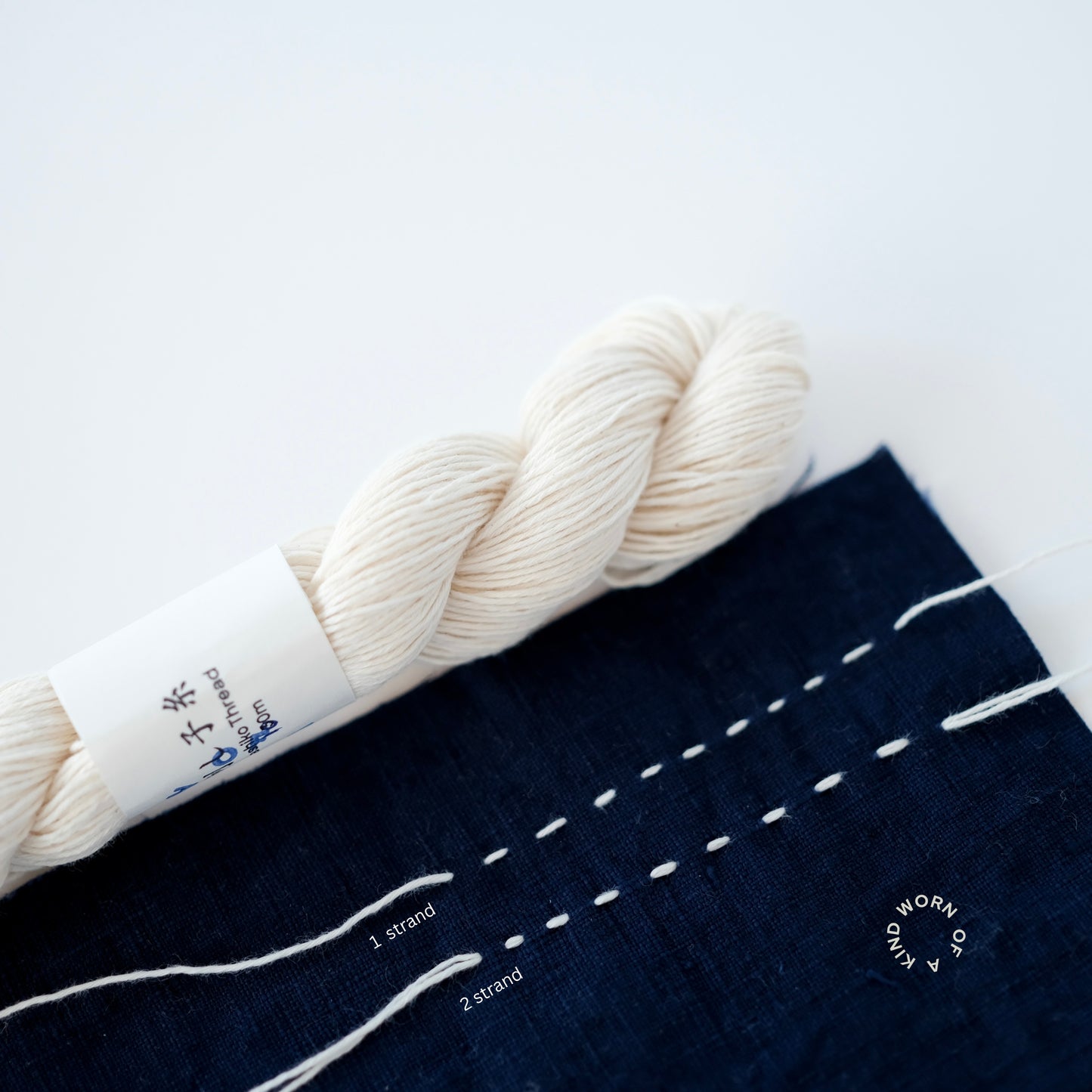 Comparison of 1-strand vs 2-strand Sashiko stitching on indigo fabric.