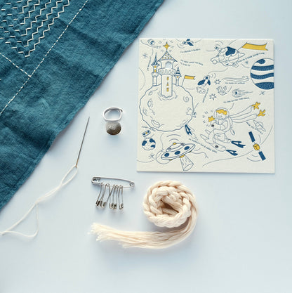 Sashiko tool set arranged with an indigo fabric sample and the artist-designed letterpress carrier card.