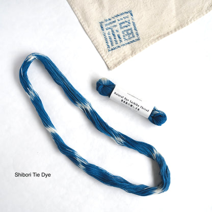Shibori tie-dye indigo Sashiko thread with a stitched sample on fabric.