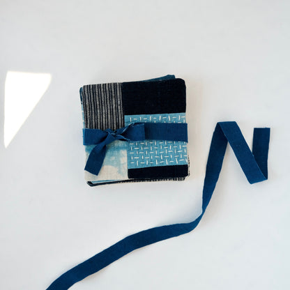 Boro coasters stacked and tied with an indigo ribbon for sustainable gifting.