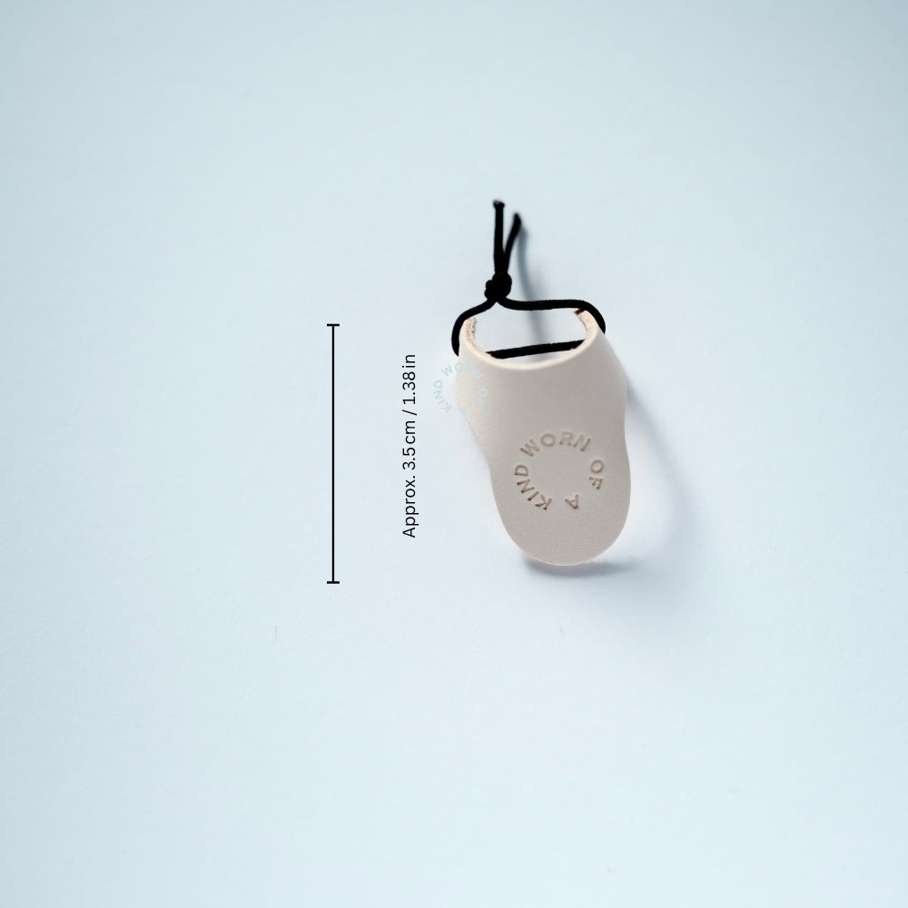 Close-up of the 3.5cm Vachetta leather thimble with etched Worn Of A Kind logo.