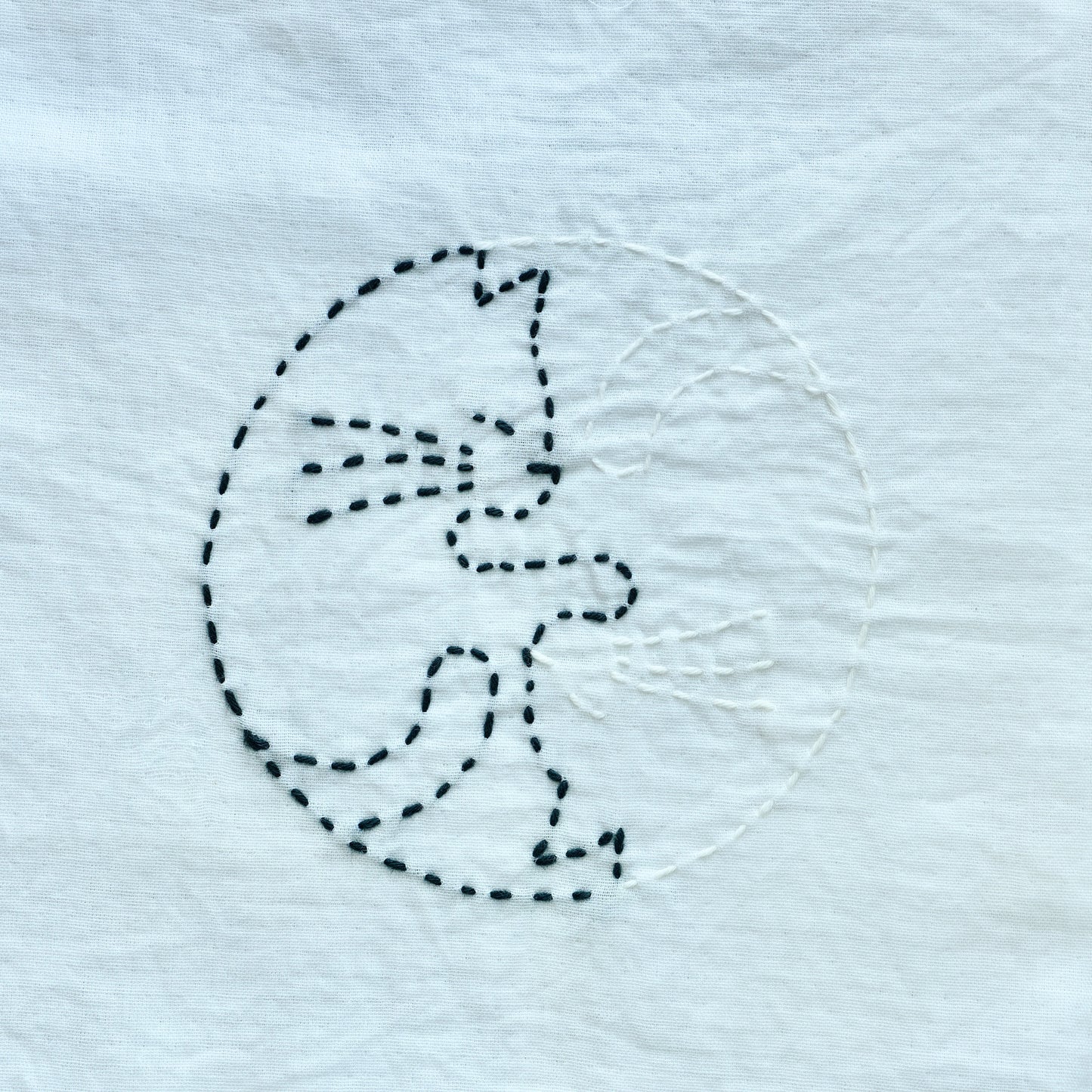 Stitched sample of a Yin-Yang style cat for the letter C in Sashiko style.