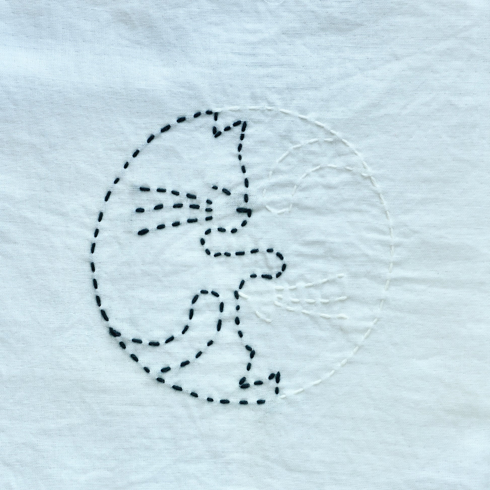 Stitched sample of a Yin-Yang style cat for the letter C in Sashiko style.